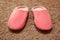 Women`s pink slippers standing on the carpet. House shoes