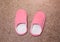 Women`s pink slippers standing on the carpet. House shoes