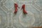 Women`s red shoes are chaotically lying on the tiled floor, abandoned