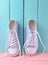 Women& x27;s retro hipster sneakers with white laces on a pink wooden floor against a blue wooden wall background