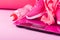 Women`s set of shoes, clothes and accessories in pink for fitness on a pink background