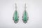 Women`s silver earrings with diamonds, green stone in the middle in the shape of a drop, isolated on a white background.