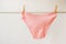 Women`s underwear. pink underpants on a light background. a piece of clothing for a person.