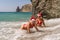 Women Santa hats ocean play. Seaside, beach daytime, enjoying beach fun. Two women in red swimsuits and Santa hats are