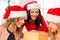 Women in santa helper hats with many gift boxes