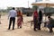 Women in sarees and face masks registering with a person sitting at a desk to receive free food rations at a donation