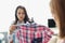 Women seamstresses taking measurements of shirts with centimeter tape and ironing with steamer