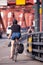 Women in shorts rides bicycle with bag on red farm bridge