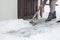 Women shoveling snow from the steps of his house