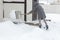 Women shoveling snow from the steps of his house