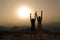 Women silhouette raising arms celebrating at sunset