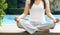 Women siting meditation on swimming pool background