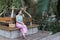 Women sitting on wooden bench in Traditional dress with handmade water hyacinth bag.