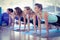 Women smiling while doing plank pose in fitness center