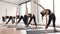 Women in sportswear doing Trikonasana exercise in studio