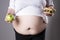 Women suffer from obesity with big hamburger and apple in hands. Junk food concept