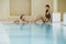 Women Talking At Edge Of Swimming Pool