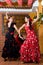 Women in traditional flamenco dresses dance during the Feria de Abril on April Spain