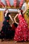 Women in traditional flamenco dresses dance during the Feria de Abril on April Spain