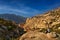 Women travel. Jordan sunset landscape. Rocky mountain with orange evening in Dana Biosphere Reserve, Jorda. Traveling in Arabia.