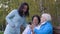 Women using mobile phone and laughing in autumn park landscape