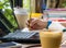 Women are using pencil to write books. Placed on a notebook computer on a wooden desk. Have coffee and a smartphone as a face blur