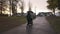 Women walking with baby in stroller. Suburban neighborhood path during dramatic sunset sky. Raining