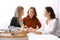 Women working at table in office, focus on basket with gadgets. Digital detox concept