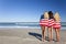 Women Wrapped in American Flags on a Beach