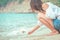 women writing heart on sand on the beach