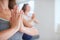 Women at yoga class meditating with hands clasped