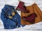 Womens clothing, accessories, footwear burgundy boots, yellow wireless headphones, denim jacket, suede skirt. Fashion outfit.