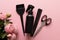 Womens day, layout of hairdressing tools on pink background with flowers, flat lay, top view