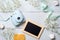 Womens desk with photo camera, picture frame, cookies. Spring minimal flowers frame, pastel colors, flat lay style, top view. Beau