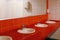 womens dressing room with red tiles on the wall, mirrors sinks for guests, toilet in the shopping center