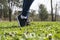 Womens feet in black sneakers on the grass on the lawn on a Sunny day , sports shoes