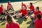 Womens Football Team Stretching Whilst Training For Soccer Match On Outdoor Astro Turf Pitch