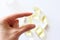 Womens hand is holding a pill. Tablets and pills laying on table.