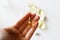 Womens hand is holding a pill. Tablets and pills laying on table.