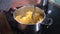 Womens hands mashing patato in pan on kitchen hob, cooking mash potato