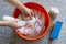 Womens hands washing dirty stained white shirts with a stain remover from a spray detergent bottle for yellow sweat stains in a