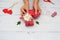 Womens hands wrappes gift for Valentine`s Day, Birthday, Mother`s Day using red textile and flowers on white background