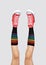 Womens legs in stylish red sneakers and rainbow socks on gray background