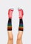Womens legs in stylish red sneakers and rainbow socks on gray background