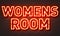 Womens room neon sign on brick wall background.