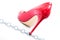 Womens shiny patent red stiletto heels and steel chain on white background