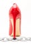 Womens shiny patent red stiletto heels and steel chain on white background