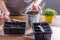 Womenâ€™s hands with garden tool cover the seeds with earth. Container for seedlings with soil and seeds. Gardening, the spring