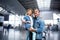 Wondered middle-aged man is standing with child in modern terminal