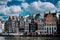 Wonderful architecture of Amsterdam. White fluffy clouds over Leaning Houses Amsterdam, Netherlands